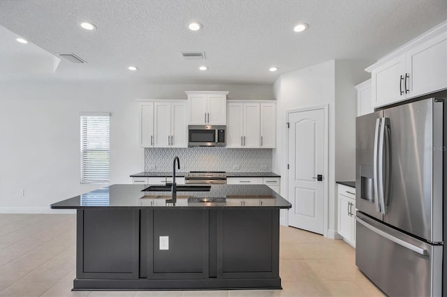 281 Potenza Loop, Nokomis, FL 34275 - kitchen with stainless steel appliances, a sink, dark countertops, decorative backsplash, and white cabinets