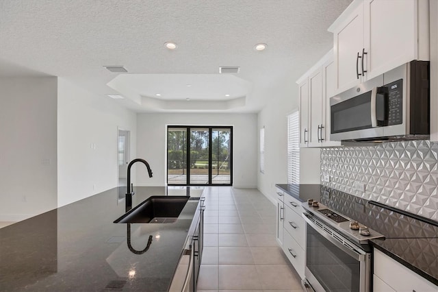 281 Potenza Loop, Nokomis, FL 34275 - kitchen with appliances with stainless steel finishes, a sink, decorative backsplash, dark stone countertops, and white cabinets