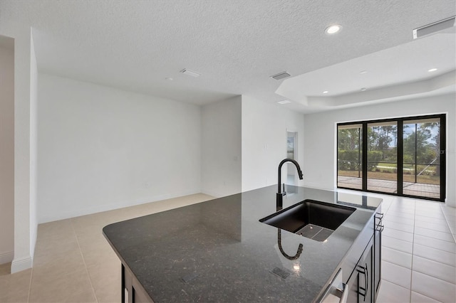 281 Potenza Loop, Nokomis, FL 34275 - kitchen with a sink, open floor plan, light tile patterned flooring, dark stone counters, and a textured ceiling