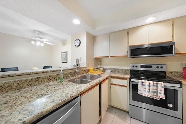 19505 Quesada Ave Unit M104, Port Charlotte, FL 33948 - kitchen with stainless steel appliances, a sink, light tile patterned flooring, recessed lighting, and cream cabinets