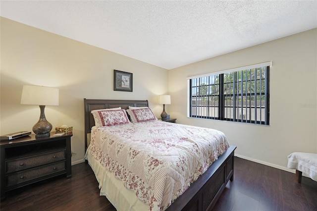 19505 Quesada Ave Unit M104, Port Charlotte, FL 33948 - bedroom featuring dark wood-style floors, baseboards, and a textured ceiling