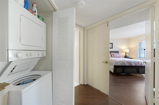 19505 Quesada Ave Unit M104, Port Charlotte, FL 33948 - washroom featuring stacked washer / dryer, a textured ceiling, and dark wood-style floors