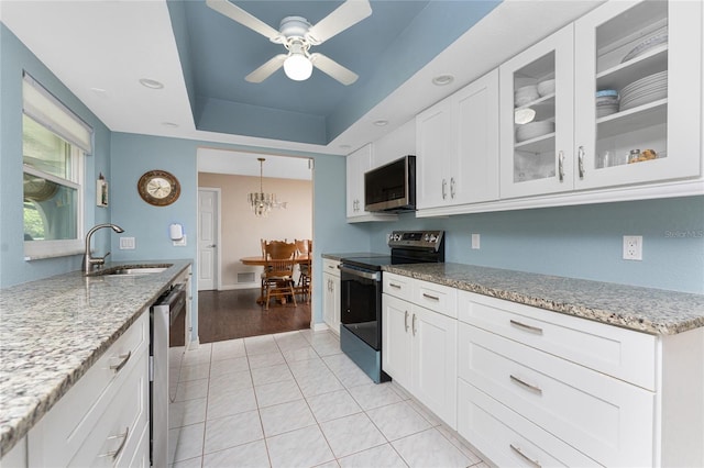 2008 Pellam Blvd, Port Charlotte, FL 33948 - kitchen with stainless steel appliances, a sink, light stone countertops, glass insert cabinets, and light tile patterned floors