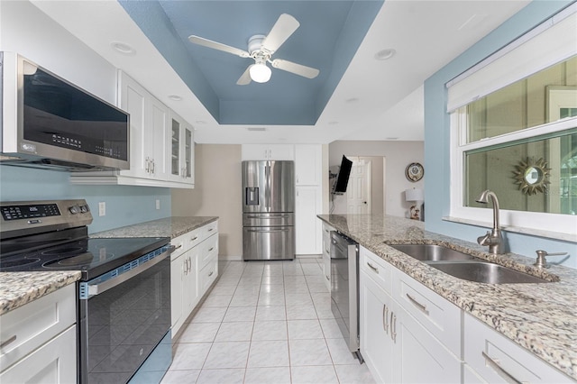 2008 Pellam Blvd, Port Charlotte, FL 33948 - kitchen with stainless steel appliances, a sink, a tray ceiling, white cabinetry, and light stone countertops
