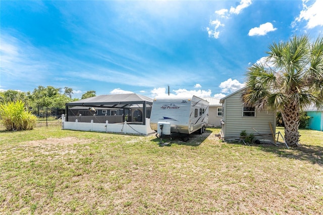 2008 Pellam Blvd, Port Charlotte, FL 33948 - rear view of house featuring a lawn and glass enclosure