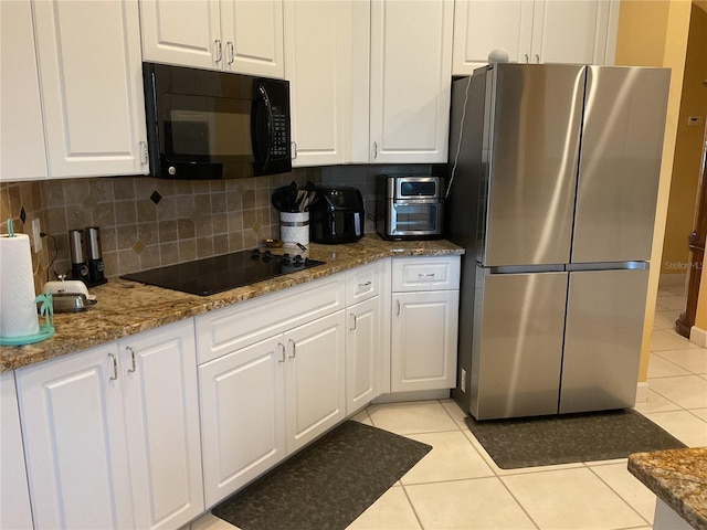 1961 Palo Duro Blvd, North Fort Myers, FL 33917 - kitchen with black appliances, light tile patterned floors, white cabinets, and backsplash