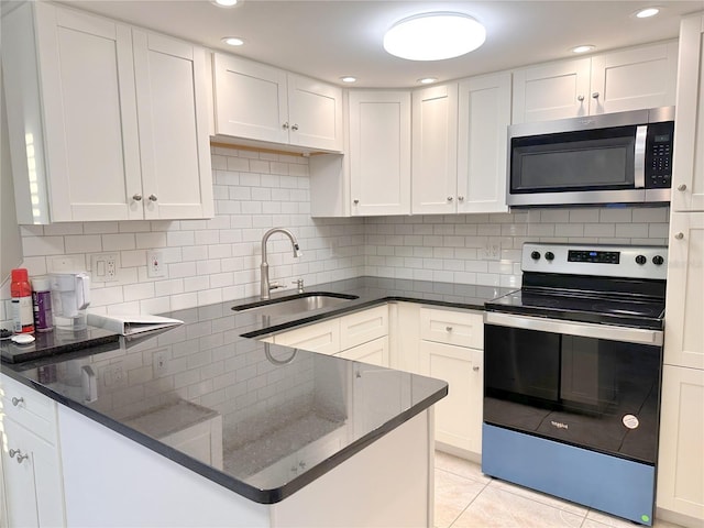 4158 Tamiami Trl Unit A5, Port Charlotte, FL 33952 - kitchen with appliances with stainless steel finishes, a sink, tasteful backsplash, white cabinetry, and dark stone counters