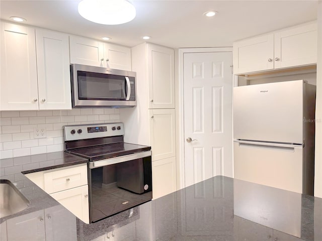 4158 Tamiami Trl Unit A5, Port Charlotte, FL 33952 - kitchen featuring appliances with stainless steel finishes, white cabinets, backsplash, dark stone countertops, and recessed lighting