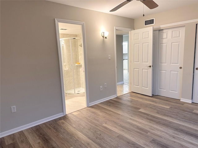 4158 Tamiami Trl Unit A5, Port Charlotte, FL 33952 - unfurnished bedroom featuring wood finished floors, baseboards, a closet, ensuite bath, and ceiling fan