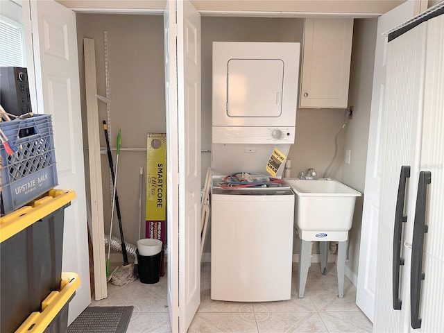 4158 Tamiami Trl Unit A5, Port Charlotte, FL 33952 - clothes washing area featuring stacked washer / drying machine, light tile patterned floors, and cabinet space