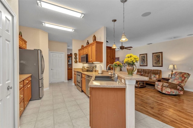 24371 Folkstone Ave, Punta Gorda, FL 33980 - kitchen with a sink, appliances with stainless steel finishes, open floor plan, a peninsula, and light tile patterned floors