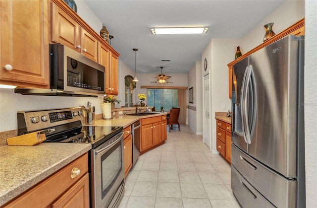 24371 Folkstone Ave, Punta Gorda, FL 33980 - kitchen with stainless steel appliances, a sink, light countertops, and brown cabinets