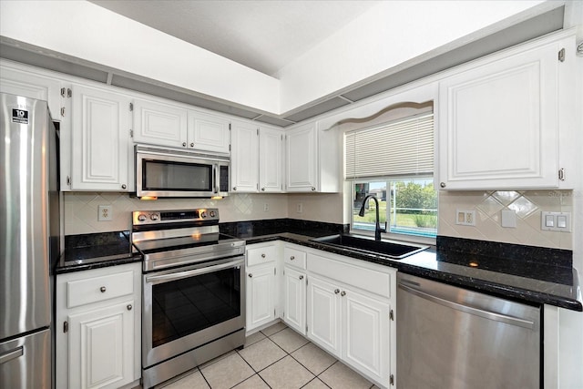 25449 Doredo Dr, Punta Gorda, FL 33955 - kitchen featuring stainless steel appliances, a sink, light tile patterned floors, and white cabinetry