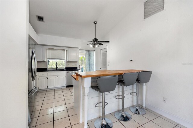 25449 Doredo Dr, Punta Gorda, FL 33955 - kitchen featuring stainless steel appliances, a breakfast bar area, white cabinetry, a sink, and baseboards
