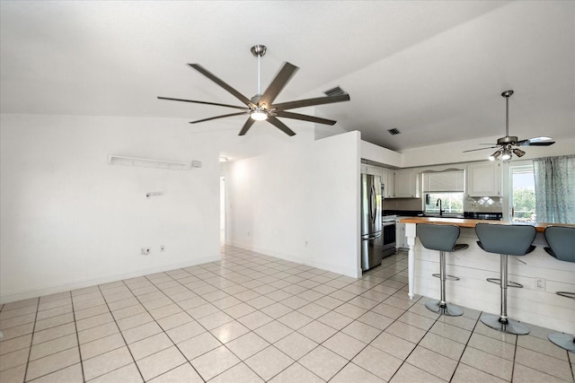 25449 Doredo Dr, Punta Gorda, FL 33955 - kitchen with a ceiling fan, stainless steel appliances, a kitchen bar, vaulted ceiling, and a sink