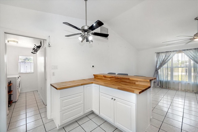 25449 Doredo Dr, Punta Gorda, FL 33955 - kitchen with wooden counters, ceiling fan, light tile patterned flooring, vaulted ceiling, and white cabinetry