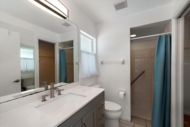 25449 Doredo Dr, Punta Gorda, FL 33955 - bathroom featuring toilet, tiled shower, vanity, a spacious closet, and tile patterned flooring