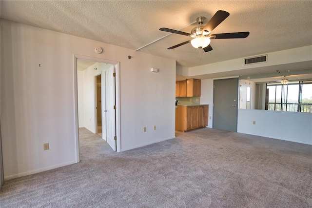 3006 Caring Way Unit 615, Port Charlotte, FL 33952 - unfurnished living room featuring a ceiling fan, a textured ceiling, light colored carpet, and baseboards
