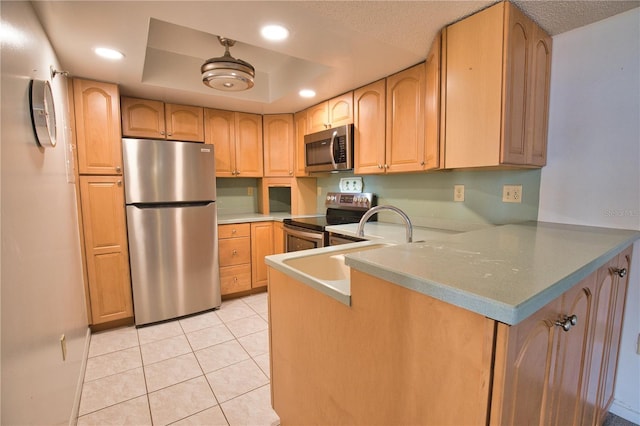 3006 Caring Way Unit 615, Port Charlotte, FL 33952 - kitchen with stainless steel appliances, a peninsula, a tray ceiling, light tile patterned flooring, and recessed lighting