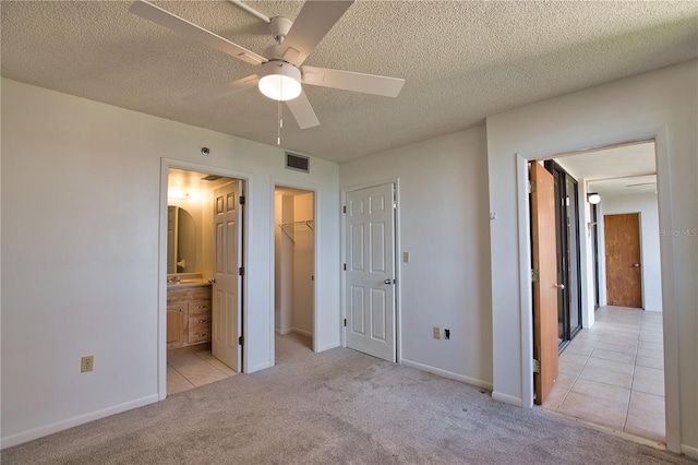 3006 Caring Way Unit 615, Port Charlotte, FL 33952 - unfurnished bedroom with carpet floors, a textured ceiling, ensuite bath, a walk in closet, and ceiling fan