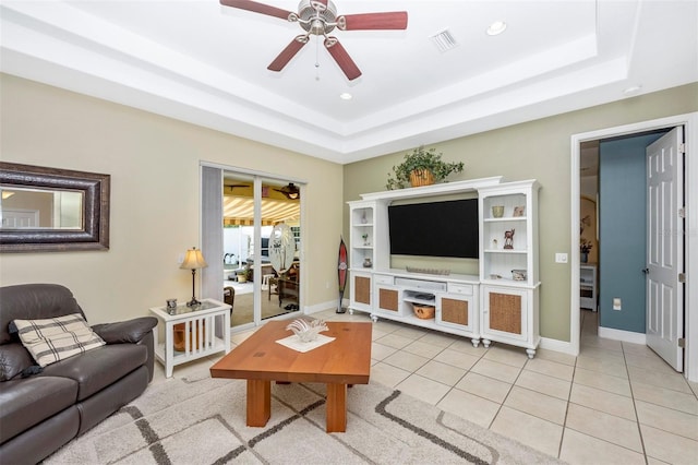 living area featuring ceiling fan, a tray ceiling, light tile patterned flooring, baseboards, and recessed lighting