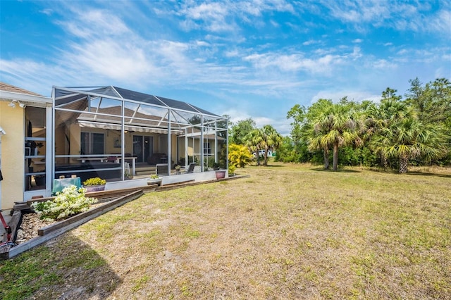 view of green lawn featuring glass enclosure
