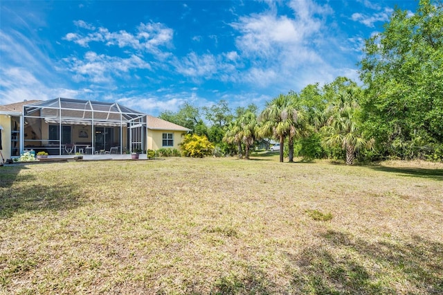 view of green lawn featuring a lanai