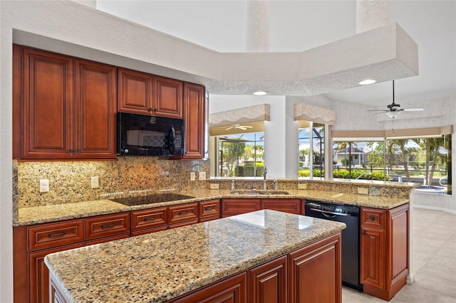 2719 Mayaguana Ct, Punta Gorda, FL 33950 - kitchen featuring black appliances, a sink, a peninsula, light tile patterned flooring, and light stone counters