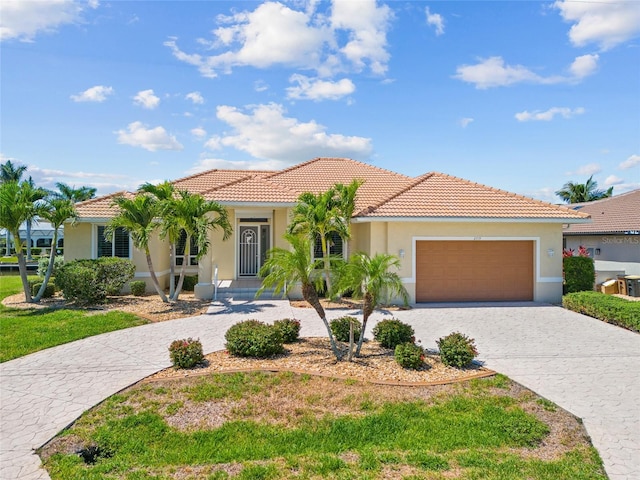 2719 Mayaguana Ct, Punta Gorda, FL 33950 - mediterranean / spanish home featuring stucco siding, an attached garage, decorative driveway, and a tile roof