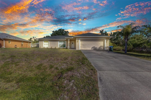 ranch-style house with a garage, driveway, stucco siding, and a front yard