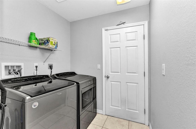 laundry room featuring washer and dryer and light tile patterned floors