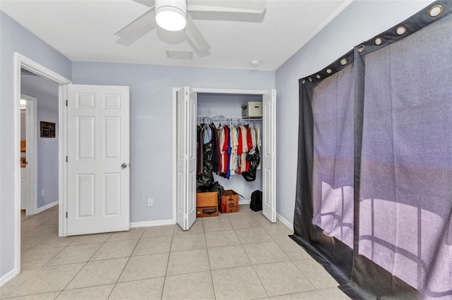 unfurnished bedroom with light tile patterned floors, baseboards, and a closet