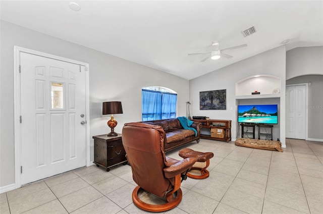 living room featuring vaulted ceiling, a ceiling fan, light tile patterned flooring, baseboards, and arched walkways
