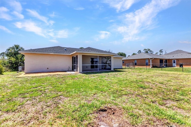back of property with stucco siding and a sunroom
