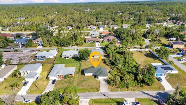 aerial view of property and surrounding area with a heavily wooded area and nearby suburban area