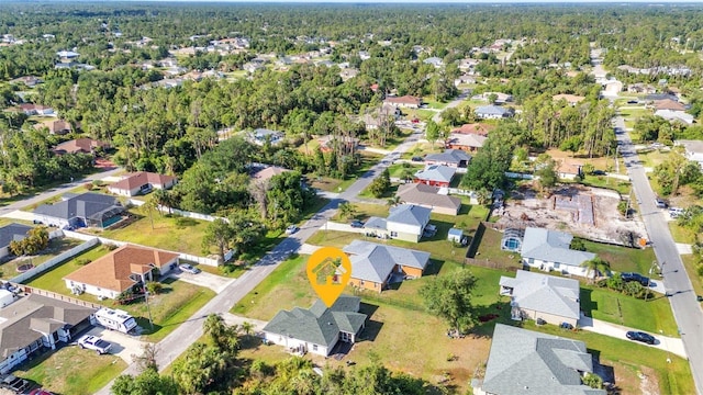 aerial view of property's location featuring nearby suburban area and a heavily wooded area