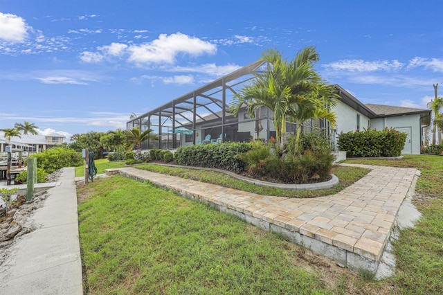 19246 Moore Haven Ct, Port Charlotte, FL 33948 - view of home's exterior featuring a lawn, glass enclosure, and stucco siding