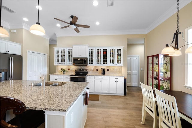 19246 Moore Haven Ct, Port Charlotte, FL 33948 - kitchen featuring stainless steel appliances, a ceiling fan, a sink, light wood-style floors, and white cabinets