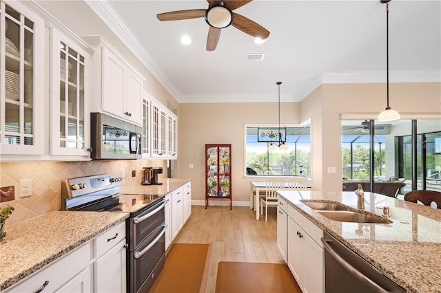 19246 Moore Haven Ct, Port Charlotte, FL 33948 - kitchen featuring appliances with stainless steel finishes, ceiling fan, light wood-style flooring, white cabinets, and ornamental molding