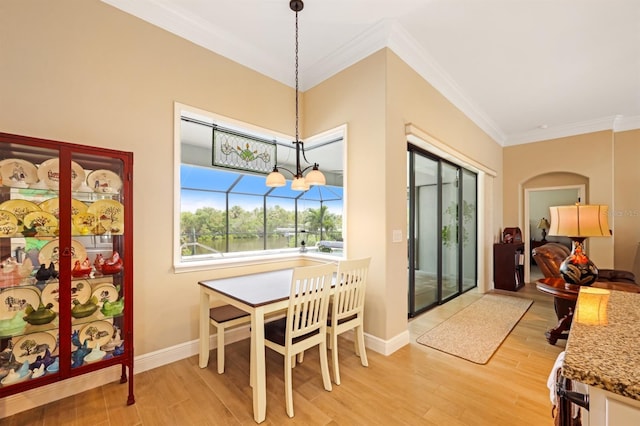 19246 Moore Haven Ct, Port Charlotte, FL 33948 - dining room featuring crown molding, light wood finished floors, baseboards, and arched walkways