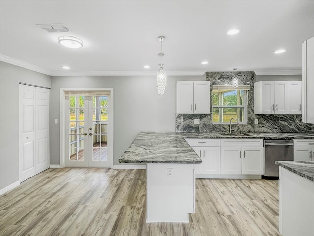 3342 Avanti Cir, North Port, FL 34287 - kitchen with stainless steel dishwasher, a sink, a peninsula, dark stone counters, and healthy amount of natural light
