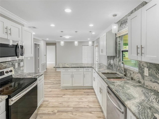 3342 Avanti Cir, North Port, FL 34287 - kitchen with stainless steel appliances, a sink, a peninsula, ornamental molding, and light wood finished floors
