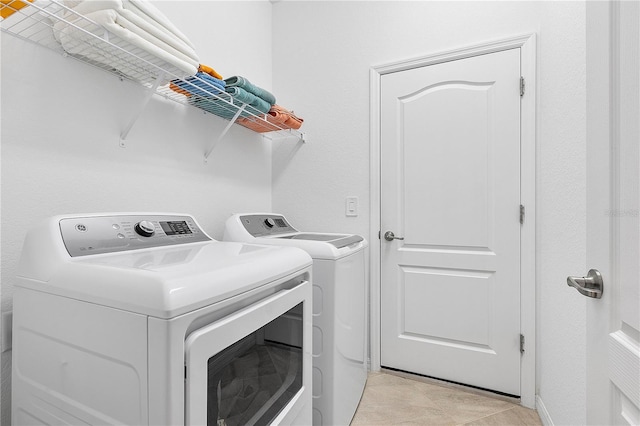 17620 Winding Wood Ln, Punta Gorda, FL 33982 - laundry room featuring washer and dryer and light tile patterned floors