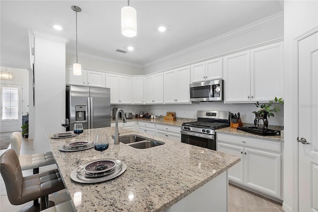 17620 Winding Wood Ln, Punta Gorda, FL 33982 - kitchen with stainless steel appliances, a sink, a breakfast bar area, white cabinetry, and decorative light fixtures