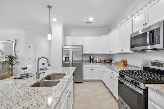 17620 Winding Wood Ln, Punta Gorda, FL 33982 - kitchen featuring stainless steel appliances, a sink, white cabinets, ornamental molding, and hanging light fixtures