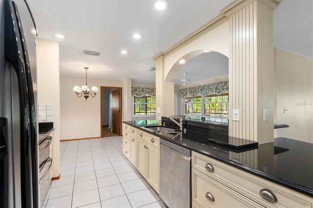 485 Dorchester St, Port Charlotte, FL 33954 - kitchen featuring stainless steel appliances, cream cabinetry, dark countertops, a sink, and a chandelier