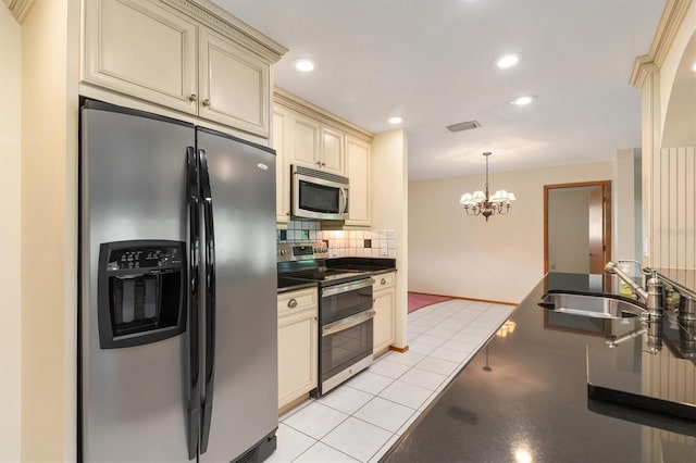 485 Dorchester St, Port Charlotte, FL 33954 - kitchen featuring cream cabinetry, stainless steel appliances, dark countertops, a sink, and a chandelier