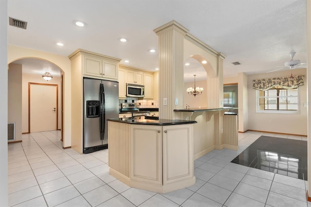 485 Dorchester St, Port Charlotte, FL 33954 - kitchen featuring cream cabinetry, appliances with stainless steel finishes, dark countertops, light tile patterned floors, and baseboards