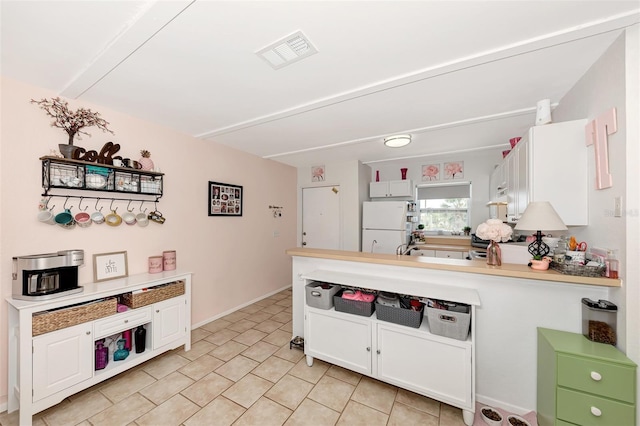 25100 Sandhill Blvd Unit F-203, Punta Gorda, FL 33983 - kitchen with freestanding refrigerator, light countertops, a peninsula, white cabinetry, and range