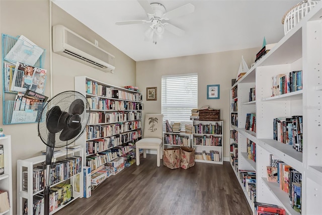 25100 Sandhill Blvd Unit F-203, Punta Gorda, FL 33983 - sitting room featuring wall of books, an AC wall unit, ceiling fan, and wood finished floors